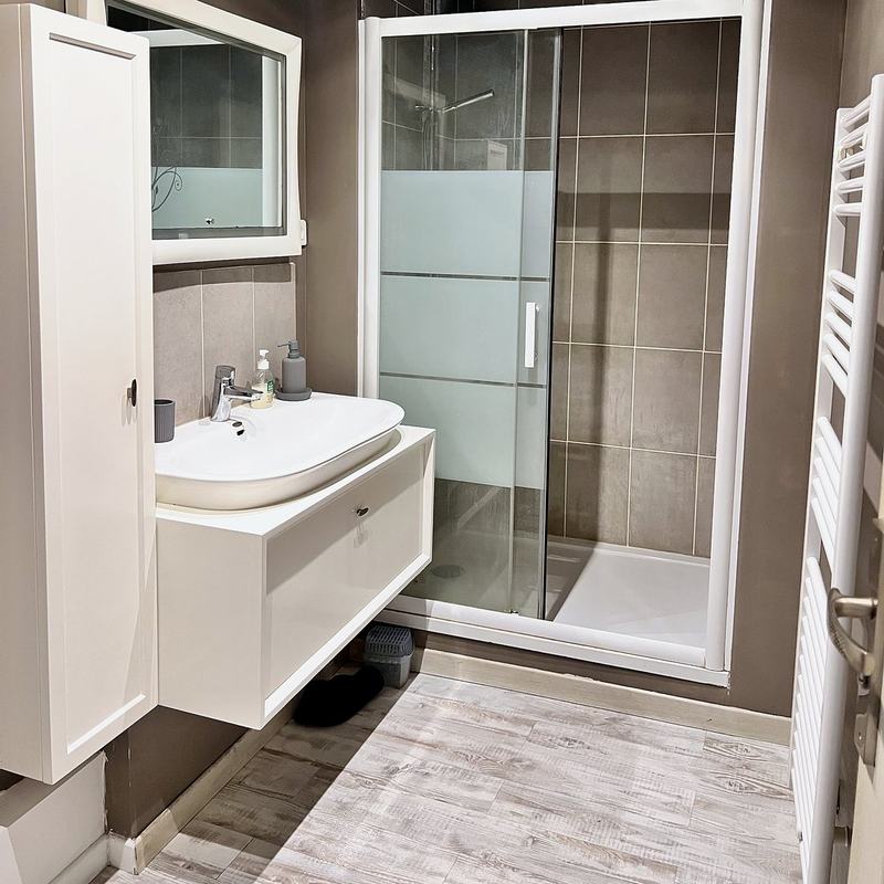 Bathroom with a walk-in shower, washbasin and towel radiator