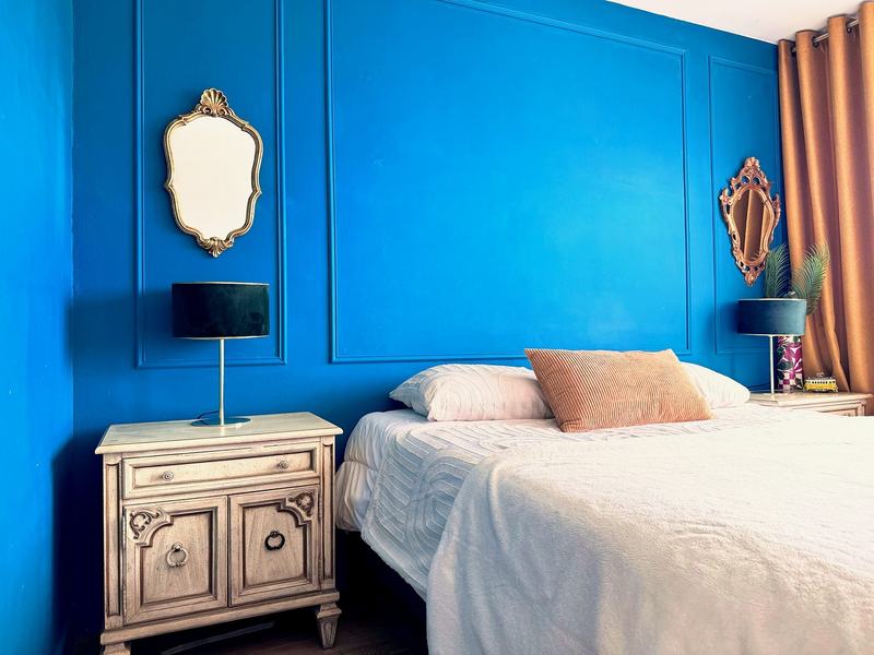 Bedroom with a double bed, a blue panelled wall and bedside tables