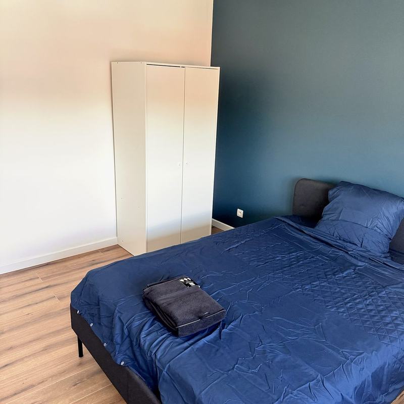 Bedroom with a double bed, wardrobe and a blue accent wall