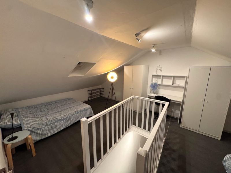 Loft bedroom with a bed, desk and wardrobes