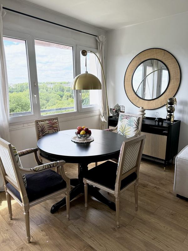 Dining area with a round table and large windows over the garden