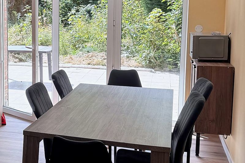 Dining area with a large table opening onto the terrace and garden
