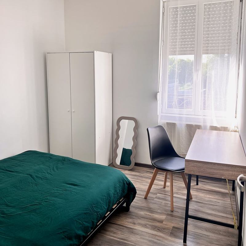 Bedroom with a bed, desk, wardrobe and a window