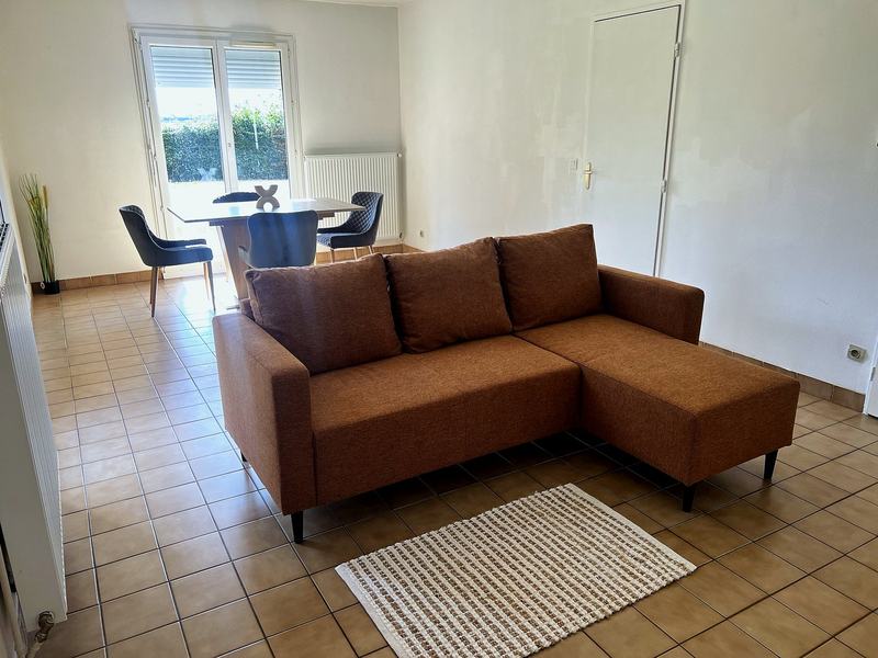 Living room with a sofa and a dining table opening onto the garden