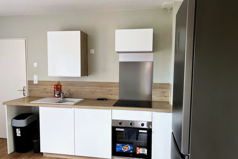Kitchen with oven, hob, sink and a large fridge-freezer