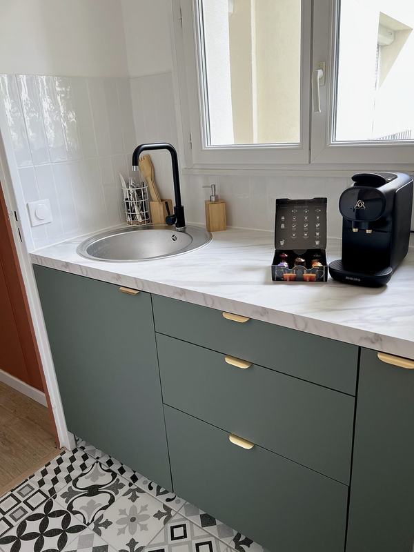 Kitchenette with a sink, a marble-effect worktop and a window