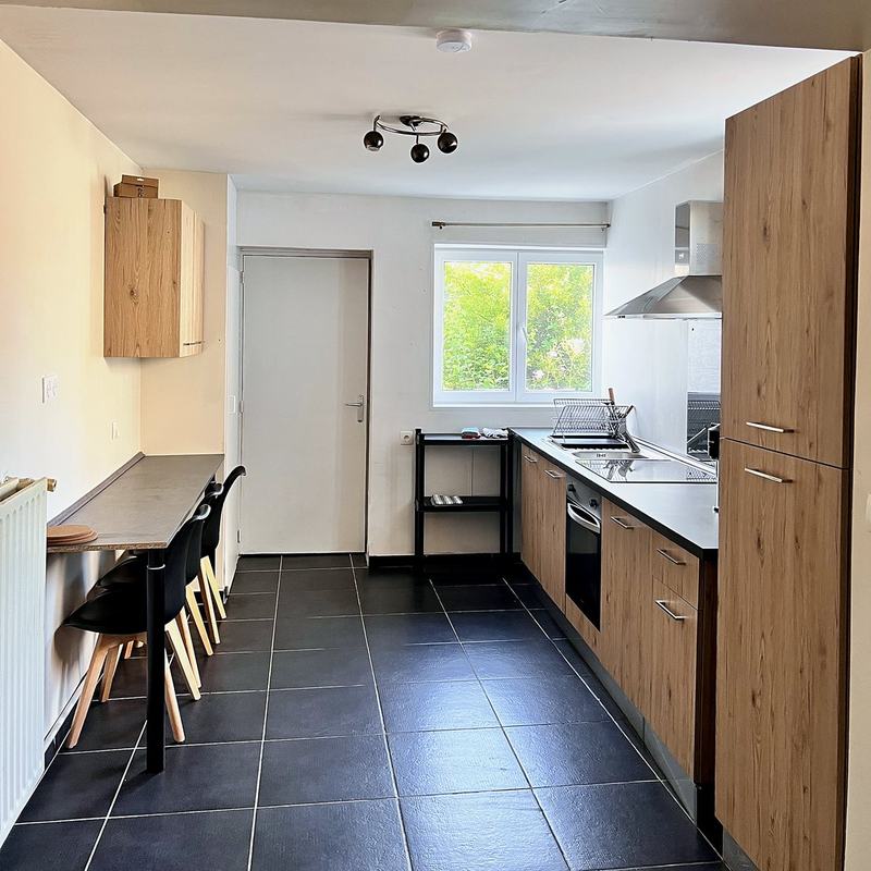 Fitted kitchen with oven, hob and a long dining table