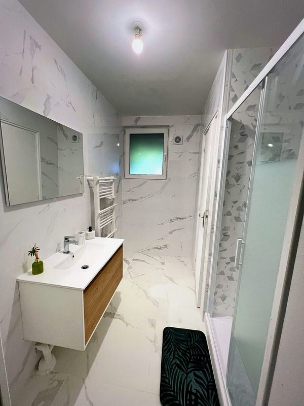 Bathroom with a vanity unit, towel radiator and a shower